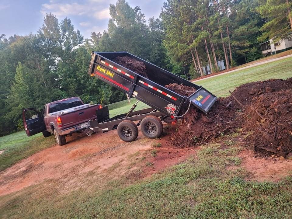 Dump trailer loaded with mulch in a driveway